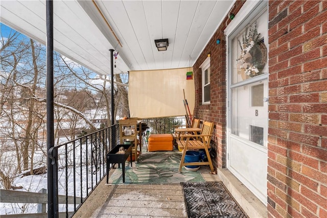 view of snow covered back of property