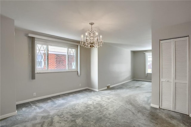 unfurnished room featuring an inviting chandelier and carpet