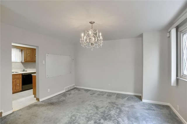 unfurnished dining area featuring an inviting chandelier and light carpet