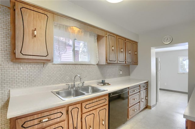 kitchen featuring white refrigerator, black dishwasher, sink, and backsplash