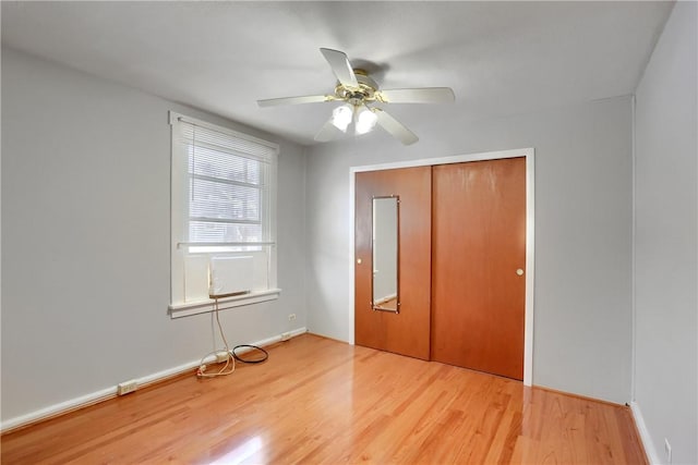 unfurnished bedroom featuring ceiling fan, hardwood / wood-style floors, and a closet