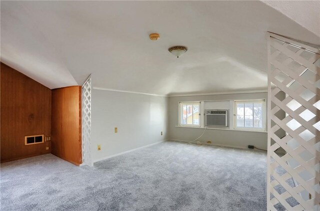 bonus room with cooling unit, light colored carpet, and wood walls