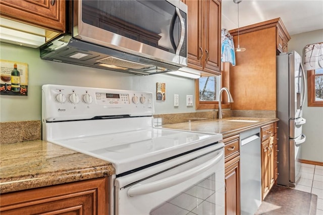 kitchen featuring light stone countertops, sink, stainless steel appliances, and tile patterned flooring