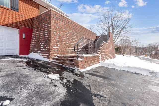 snow covered property featuring a garage