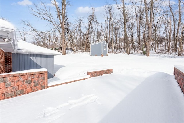 yard covered in snow featuring a shed