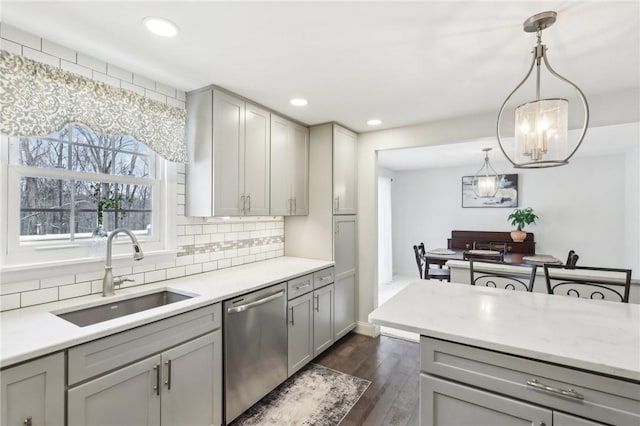 kitchen featuring dishwasher, decorative light fixtures, sink, dark hardwood / wood-style floors, and gray cabinets