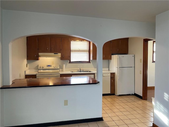 kitchen with sink, white appliances, and light tile patterned floors