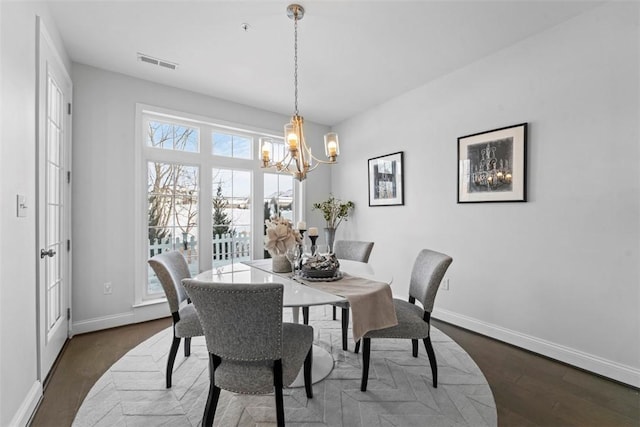 dining room featuring dark hardwood / wood-style flooring and an inviting chandelier