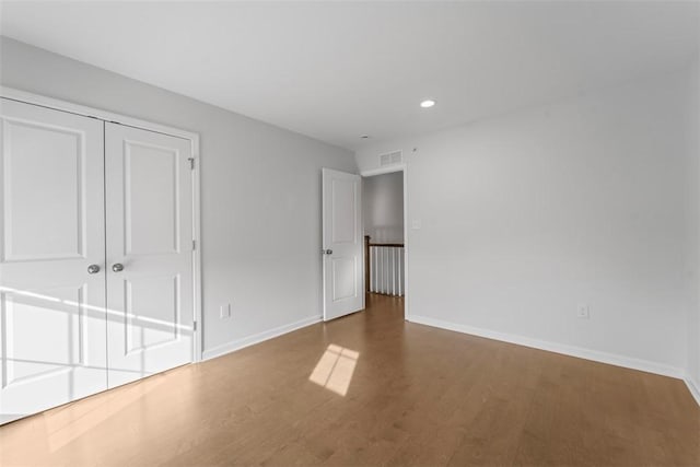 unfurnished bedroom featuring hardwood / wood-style flooring and a closet