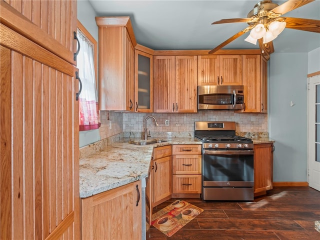 kitchen with light stone countertops, appliances with stainless steel finishes, dark hardwood / wood-style flooring, tasteful backsplash, and sink