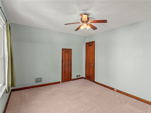 spare room with ceiling fan, light carpet, and lofted ceiling