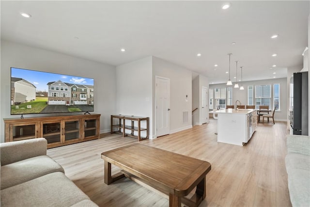 living room with sink and light hardwood / wood-style flooring