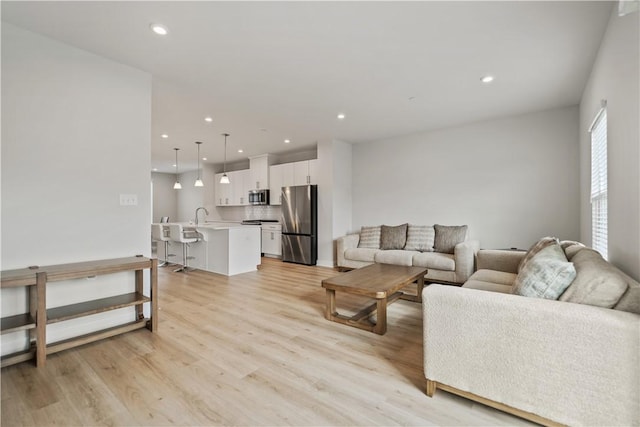 living room with sink and light hardwood / wood-style flooring