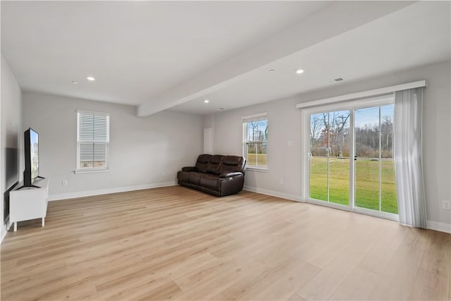 unfurnished room with light wood-type flooring and beam ceiling