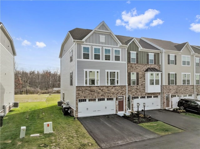 view of front facade with a garage, cooling unit, and a front lawn