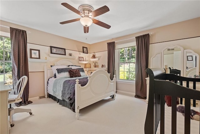 carpeted bedroom with multiple windows and ceiling fan