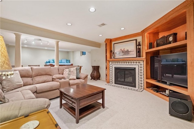 living room with crown molding, a tiled fireplace, and light colored carpet