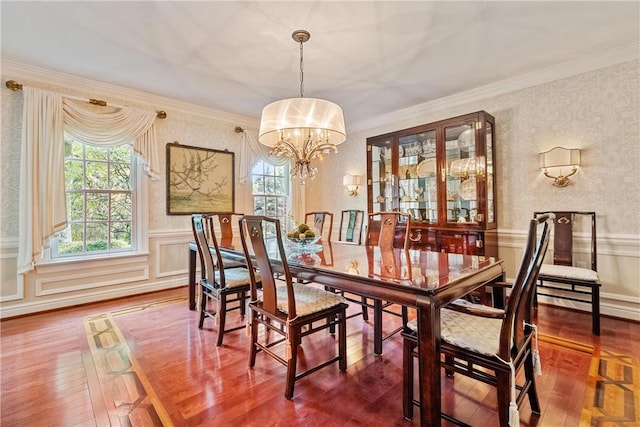 dining room with a chandelier, hardwood / wood-style flooring, a wealth of natural light, and crown molding