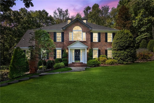 colonial inspired home featuring a lawn