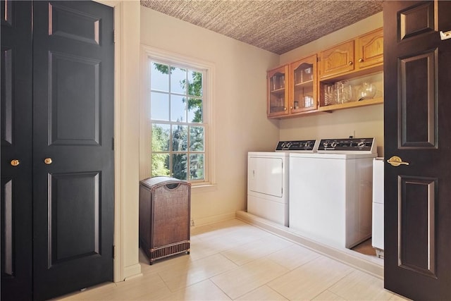 washroom featuring cabinets and washing machine and clothes dryer