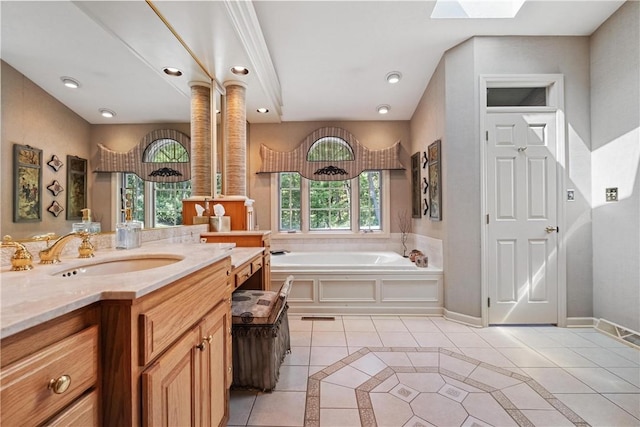 bathroom with vanity, a skylight, a bathing tub, and tile patterned flooring