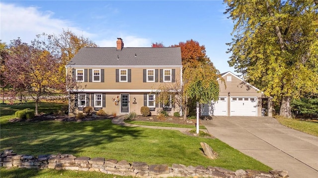 colonial house featuring a garage and a front lawn