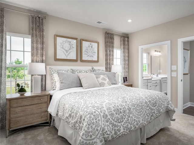 bedroom featuring ensuite bath and dark carpet