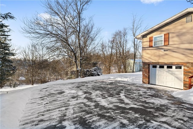 snow covered property with a garage