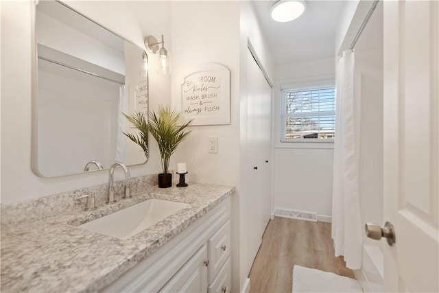 bathroom with wood-type flooring, vanity, and a shower with shower curtain