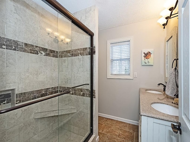 bathroom featuring an enclosed shower, vanity, and a textured ceiling