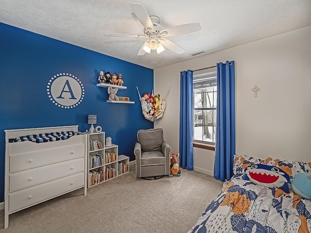 carpeted bedroom featuring a textured ceiling and ceiling fan