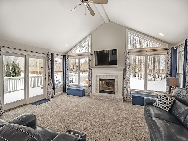 living room featuring high vaulted ceiling, carpet floors, ceiling fan, a brick fireplace, and beam ceiling