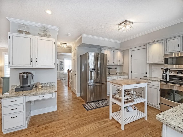 kitchen featuring stainless steel appliances, white cabinetry, plenty of natural light, and a textured ceiling