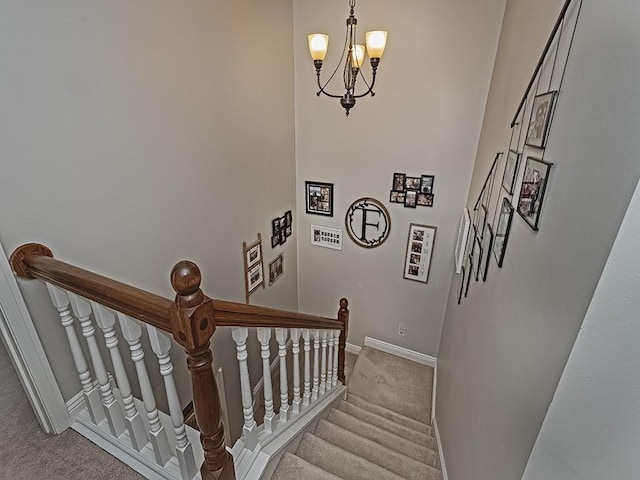 stairs with an inviting chandelier and carpet floors