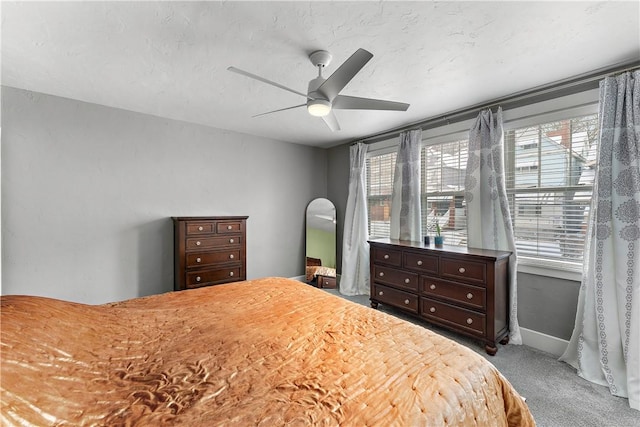 carpeted bedroom with ceiling fan and multiple windows