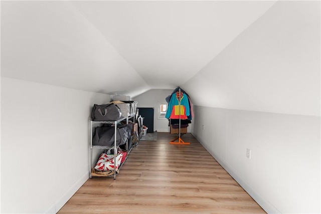 additional living space with light hardwood / wood-style floors and vaulted ceiling