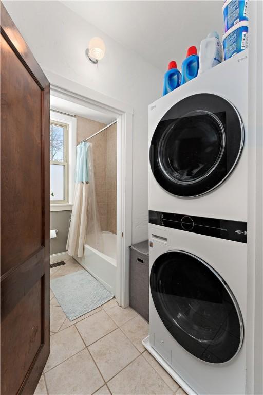 washroom featuring stacked washer / dryer and light tile patterned flooring