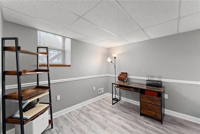 office space with a paneled ceiling and light hardwood / wood-style floors