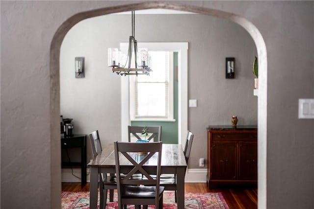 dining room with hardwood / wood-style floors and a notable chandelier