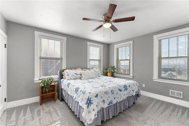 bedroom with ceiling fan, multiple windows, and carpet