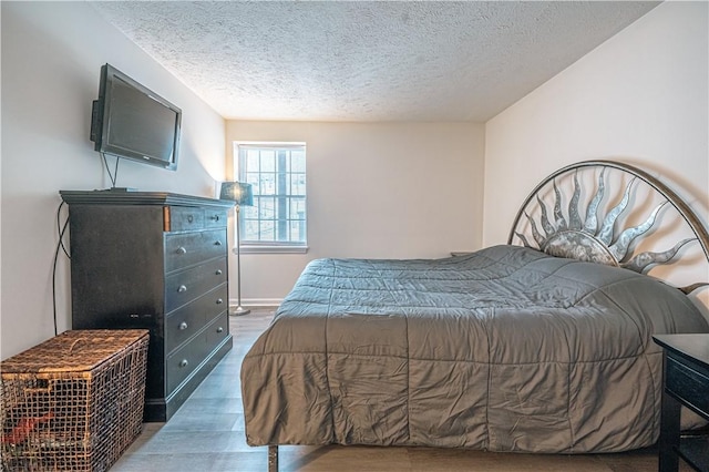 bedroom featuring dark hardwood / wood-style flooring and a textured ceiling