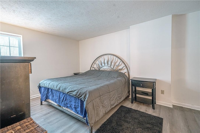 bedroom featuring wood-type flooring and a textured ceiling