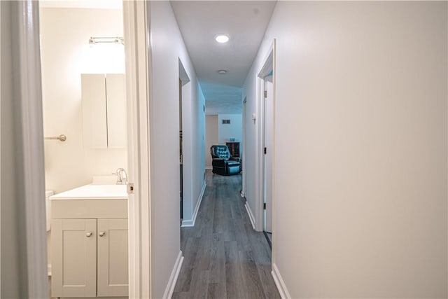 hallway with sink and dark wood-type flooring