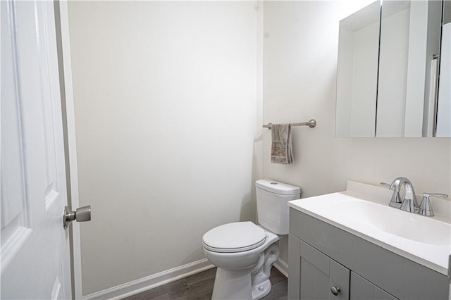 bathroom with vanity, toilet, and wood-type flooring