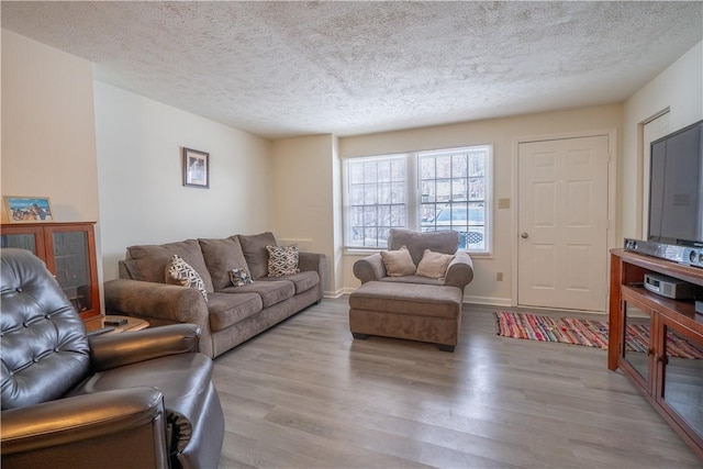 living room with light hardwood / wood-style floors and a textured ceiling