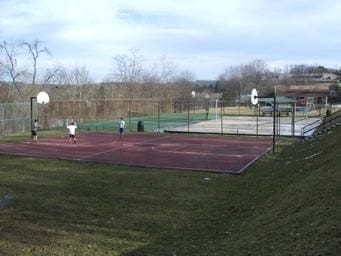 view of tennis court featuring a yard and basketball court