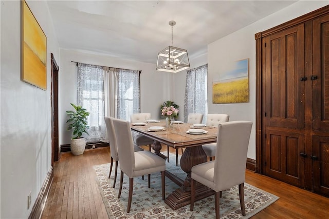 dining space featuring wood-type flooring and a chandelier