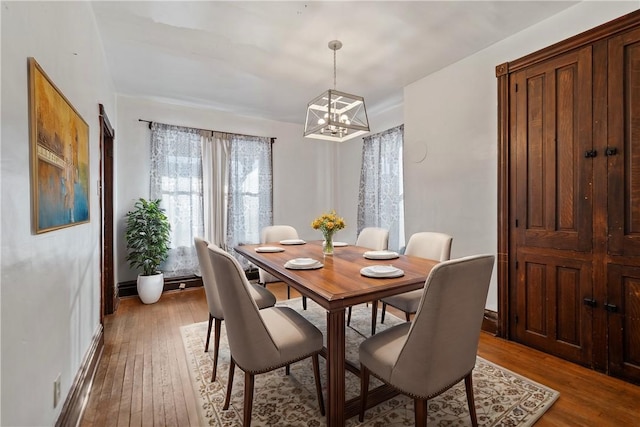 dining area with a notable chandelier and light hardwood / wood-style flooring