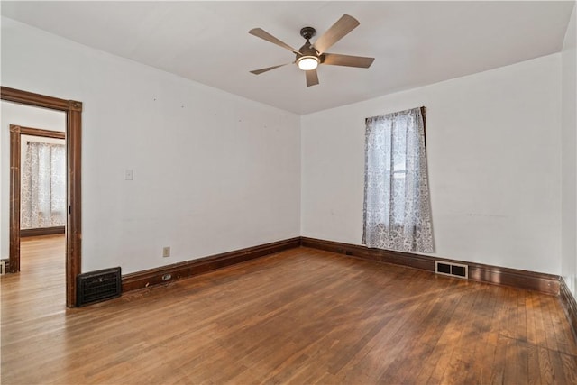 empty room with ceiling fan and hardwood / wood-style floors