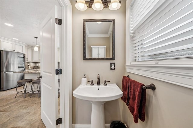 bathroom with sink and ornamental molding